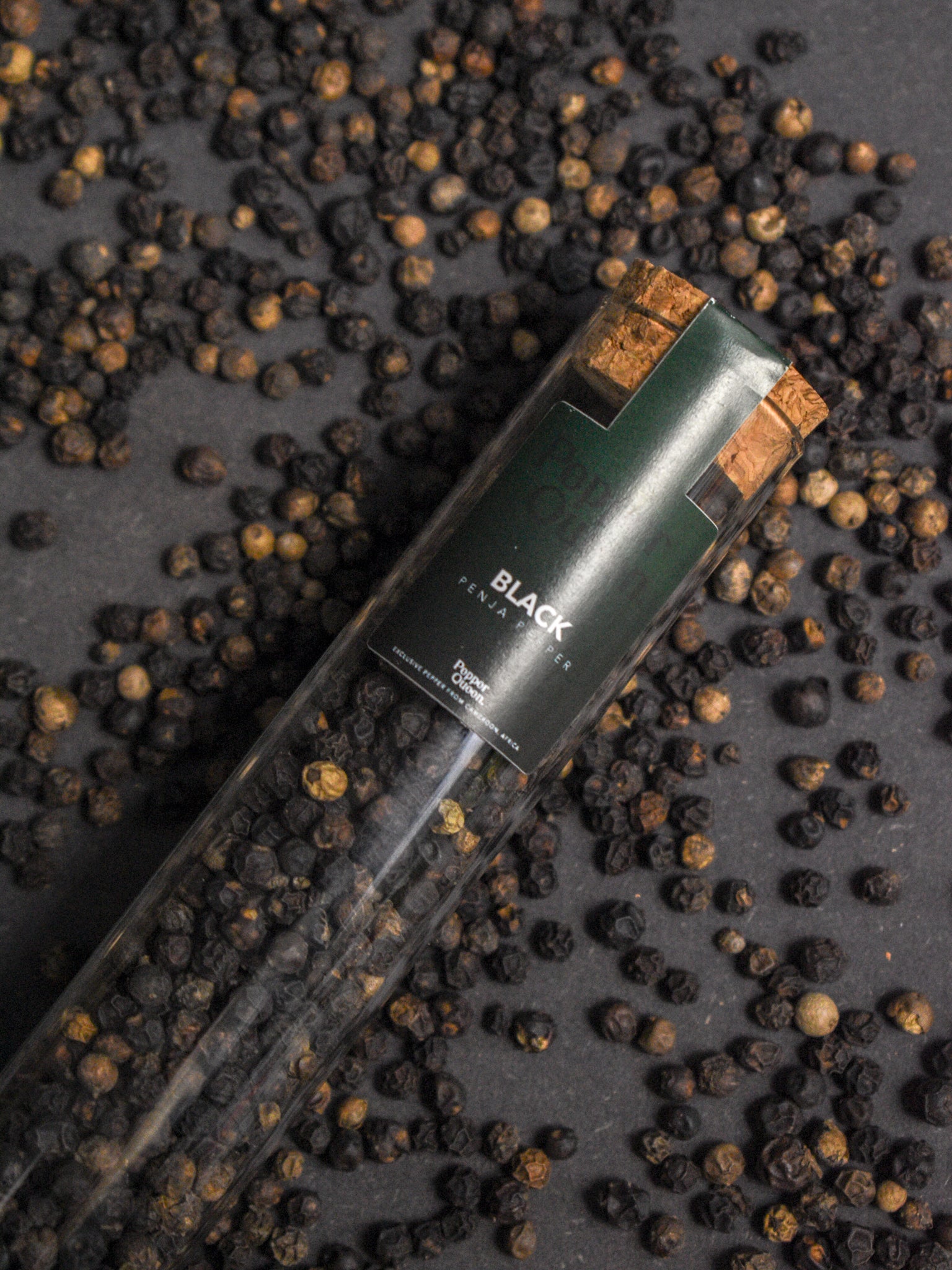 Glazen buisje gevuld met zwarte Penja peper