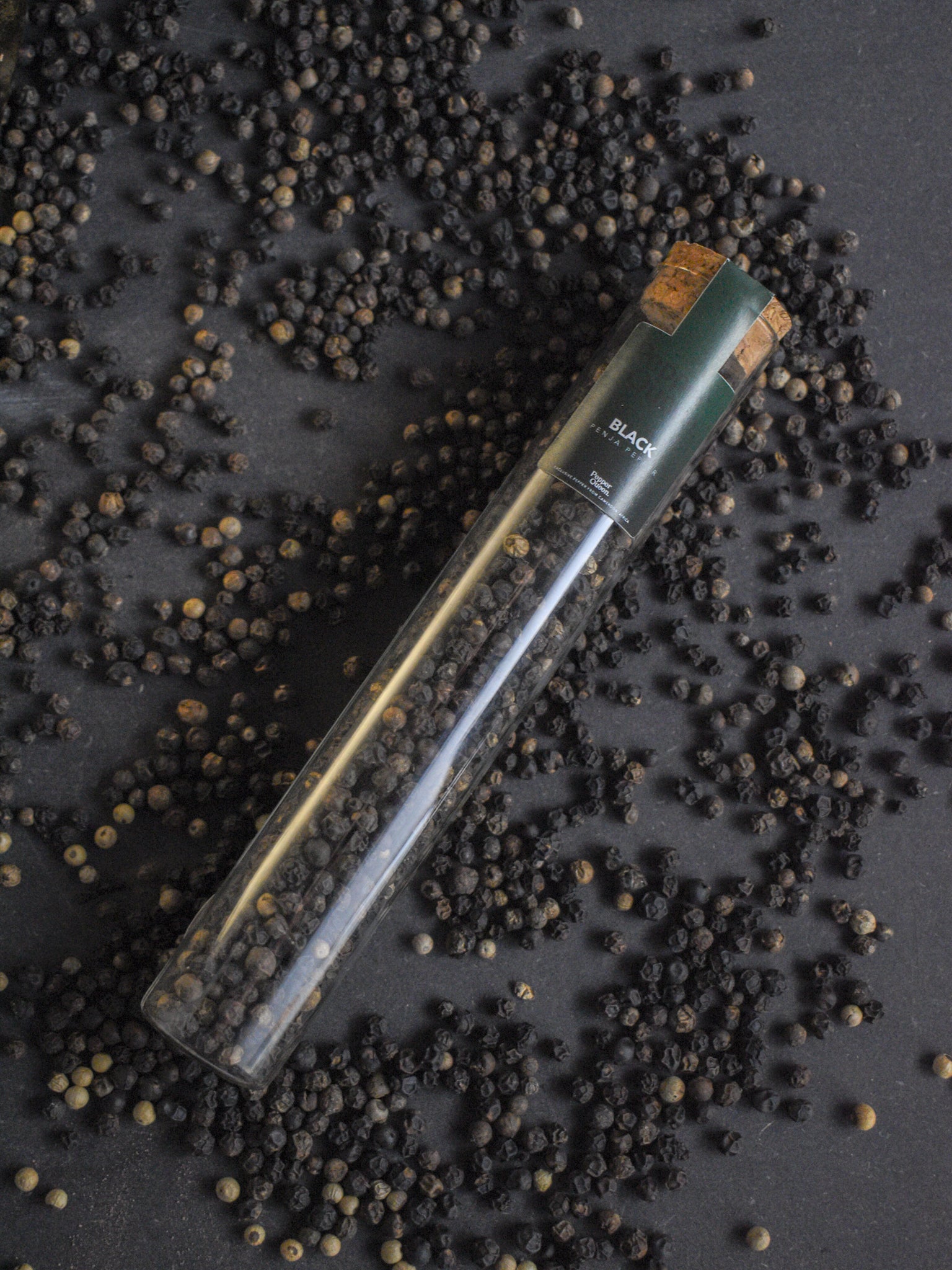 Glazen buisje gevuld met zwarte Penja peper