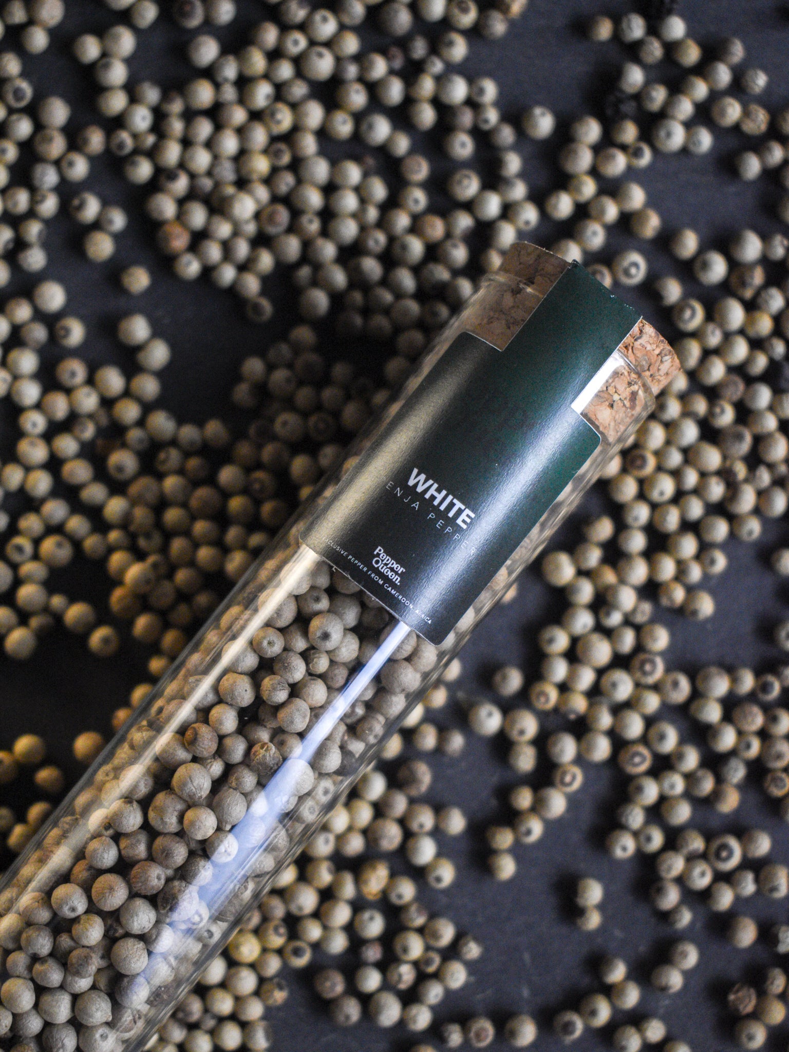 Glazen buisje gevuld met witte Penja peper